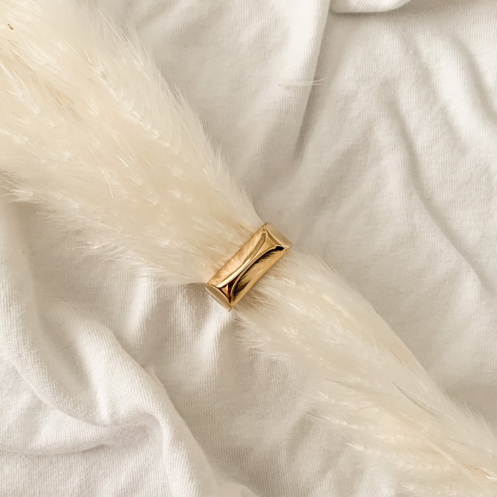 Gold ring on a white fur surface