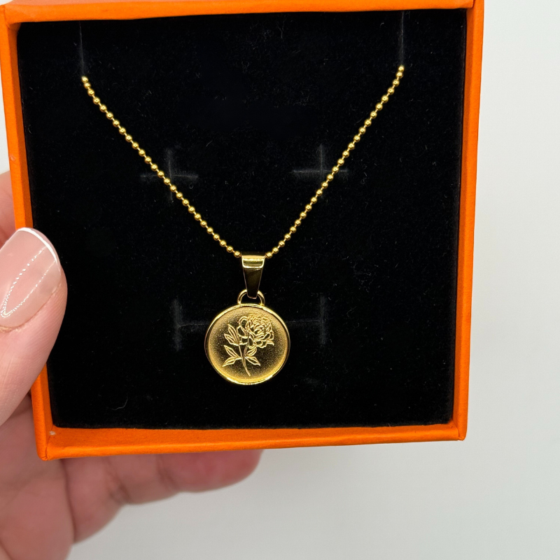 Gold necklace with a rose pendant in an orange box