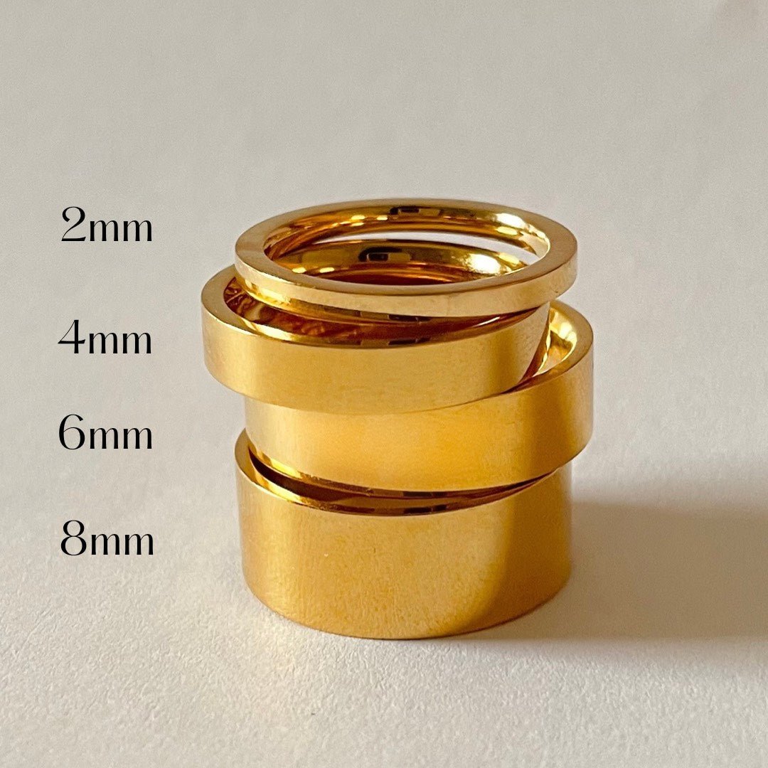 Three gold rings of different thicknesses with measurements on a light background
